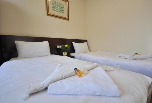 a bedroom with two beds with white sheets at Hotel Baykal in Istanbul