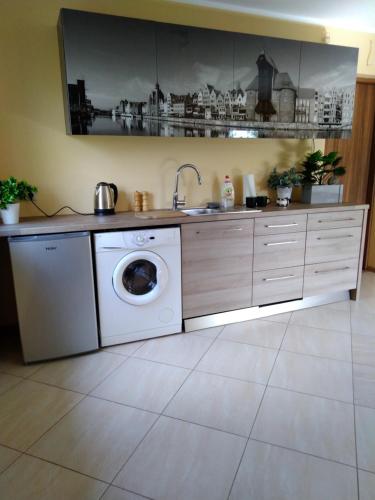 a kitchen with a washing machine and a sink at Zaścianek Kaszub in Strzebielino