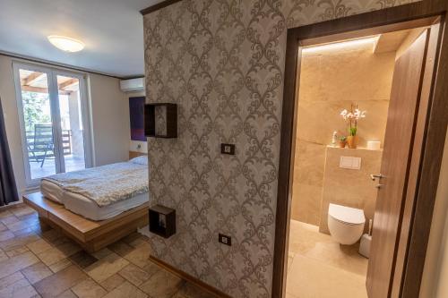 sypialnia z łóżkiem i drzwiami do łazienki w obiekcie ANGELO w Koprze