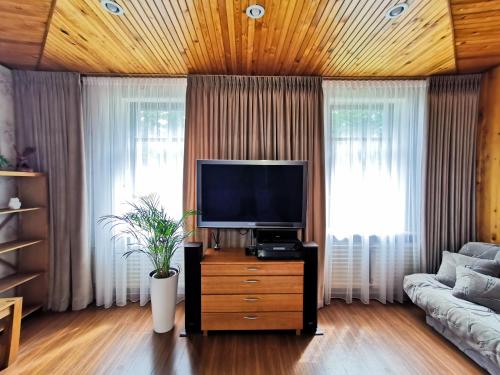 a living room with a flat screen tv on a dresser at Kambarių nuoma ant marių kranto in Juodkrantė