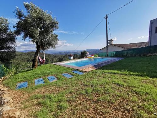 a villa with a swimming pool and a tree at Casa Mendes Lopes in Celorico de Basto