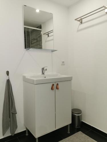 a white bathroom with a sink and a mirror at Casa Mendes Lopes in Celorico de Basto
