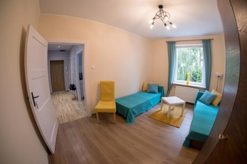 a living room with a blue couch and a yellow chair at Miraua 1 in Gdańsk