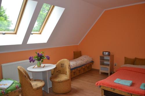 a bedroom with a bed and a table and two windows at Gospodarstwo Agroturystyczne Damroka in Szymbark
