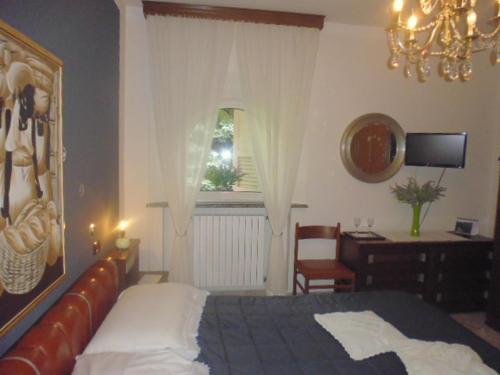 a bedroom with a bed and a desk and a window at A casa di Lara in Beura