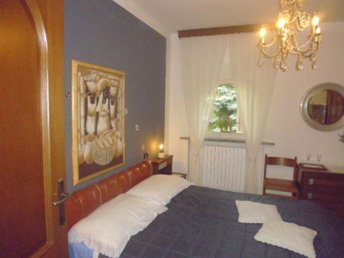a bedroom with a large bed and a chandelier at A casa di Lara in Beura