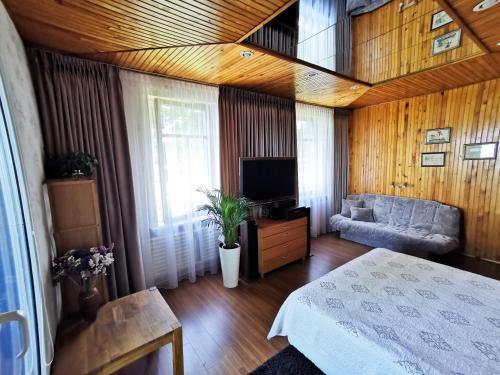 Habitación con cama, sofá y TV. en Kambarių nuoma ant marių kranto en Juodkrantė