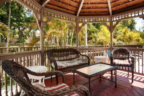 a wooden gazebo with chairs and a table on a porch at Days Inn & Suites by Wyndham Bonita Springs North Naples in Bonita Springs