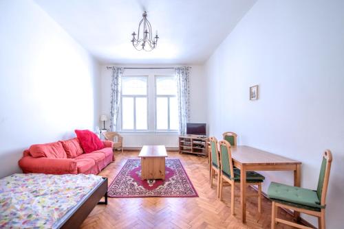 a living room with a red couch and a table at Apartments Vezenska in Prague
