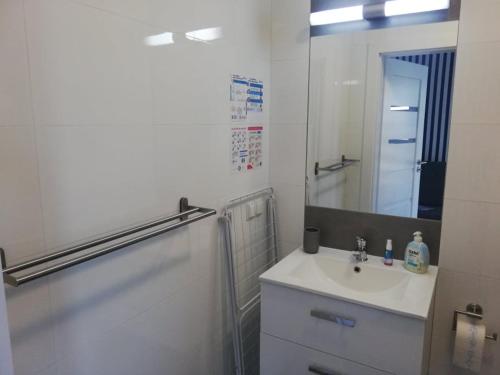 a white bathroom with a sink and a mirror at MARKAS in Rewa