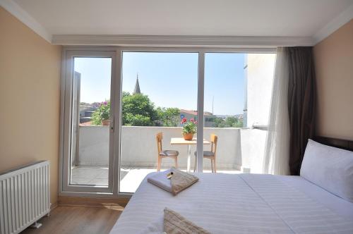 a bedroom with a bed and a view of a balcony at Hotel Baykal in Istanbul