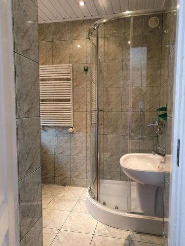 une salle de bain avec douche et lavabo dans l'établissement Willa SOL, à Mielno