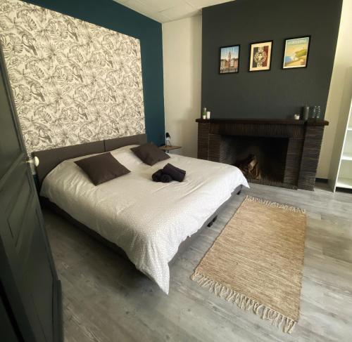 a bedroom with a bed and a fireplace at La Maison Sévigné - Appart Hôtel - N°1 in Béthune