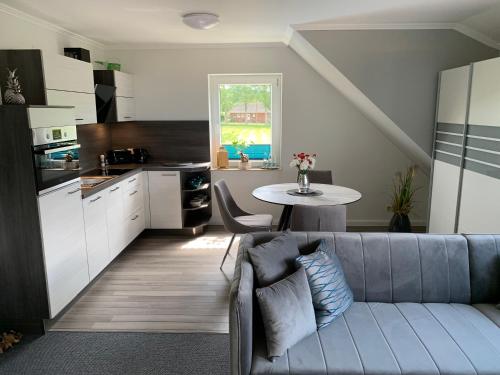 ein Wohnzimmer mit einem Sofa und einem Tisch in der Küche in der Unterkunft Ferienwohnungen Arkonablick in Lohme