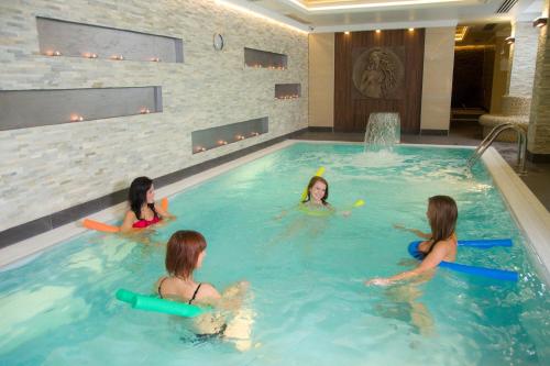 un grupo de chicas jugando en una piscina en Hotel & SPA Odeon, en Boguchwała