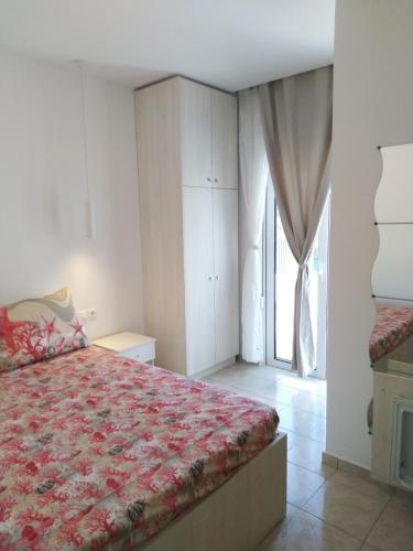 a bedroom with a bed and a large window at Bouganville Bed & Breakfast Stegna in Archangelos