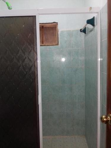 a shower with a glass door in a bathroom at Hotel Nueva Alianza in Frontera Corozal