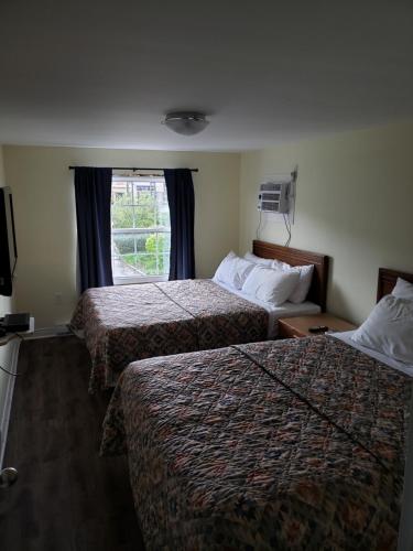a hotel room with two beds and a window at Homeward Inns of Canada in Antigonish