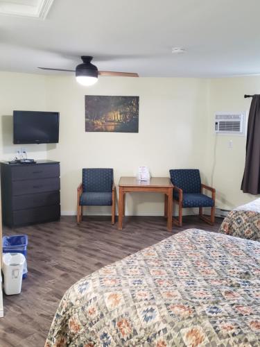 a hotel room with two beds and a table and chairs at Homeward Inns of Canada in Antigonish
