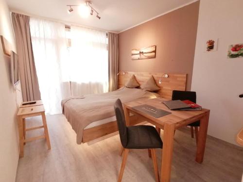 a bedroom with a bed and a desk with a laptop at Studio am Schluchsee mit Balkon Pool Fitness inkl in Schluchsee
