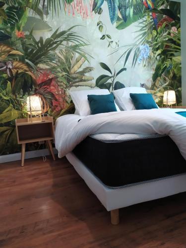 sypialnia z łóżkiem z tropikalną tapetą w obiekcie Les Loges de Montauban w mieście Montauban