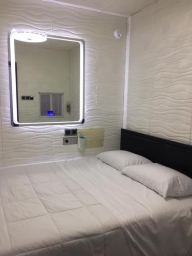 Hotel BnB-1 في شيكاغو: غرفة نوم بسرير أبيض مع مرآة