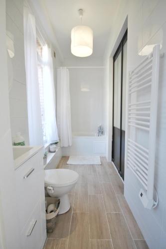 une salle de bain blanche avec des toilettes et un lavabo dans l'établissement Villers-sur-Mer, à Villers-sur-Mer