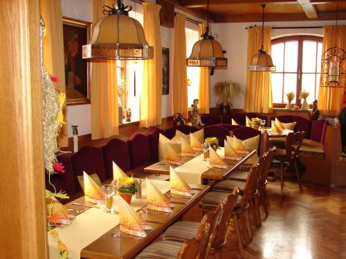 une salle à manger avec de longues tables et chaises dans l'établissement Gasthaus zur Traube, à Winterrieden