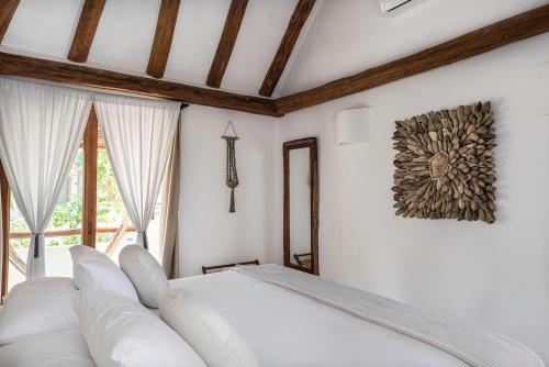 a white bed in a room with a window at Tierra del Mar Hotel - Adults Only in Holbox Island