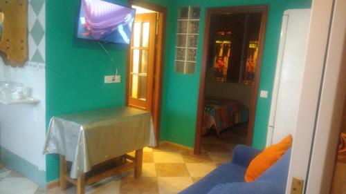 ein Wohnzimmer mit grünen Wänden und einem blauen Sofa in der Unterkunft HABITACION LILA in Barbate