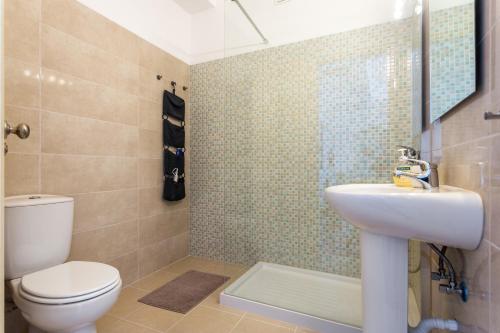 a bathroom with a white toilet and a sink at Sea View Fairy Tale in Faro