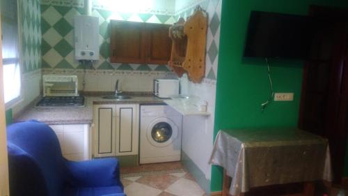 eine kleine Küche mit einer Waschmaschine in der Ecke in der Unterkunft HABITACION LILA in Barbate