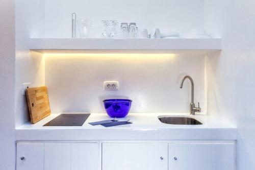 a kitchen with a sink and a blue bowl on a counter at Flag Suites in Pollonia