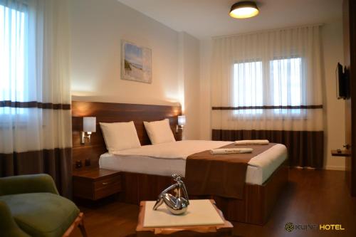 a hotel room with a bed and a chair at Kuint Hotel in Peje