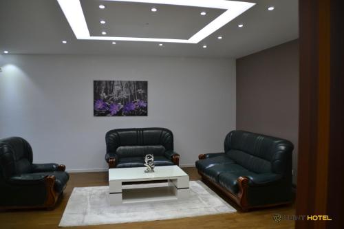 two leather chairs and a coffee table in a waiting room at Kuint Hotel in Peje