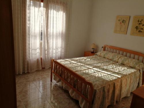 un dormitorio con una cama y una ventana en Bungalow Catral 20 en Santa Pola, en Santa Pola