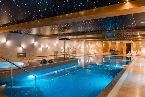 een zwembad met een hot tub in een hotel bij Hotel Podklasztorze in Sulejów