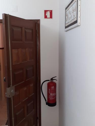 a fire hydrant is sitting next to a door at OCEAN VIEW Quartos in Faro