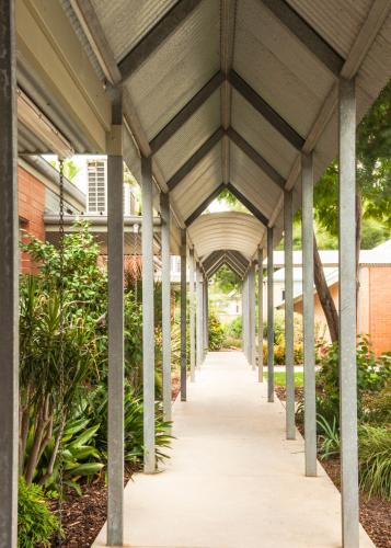 a covered walkway in a building with plants at Strath Motel in Strathalbyn