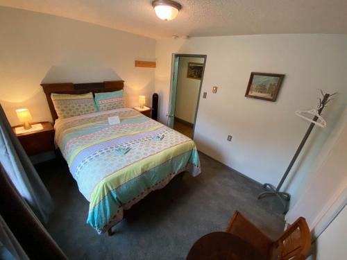 a bedroom with a bed and a lamp in it at Historic Hotel Bayview in Stewart
