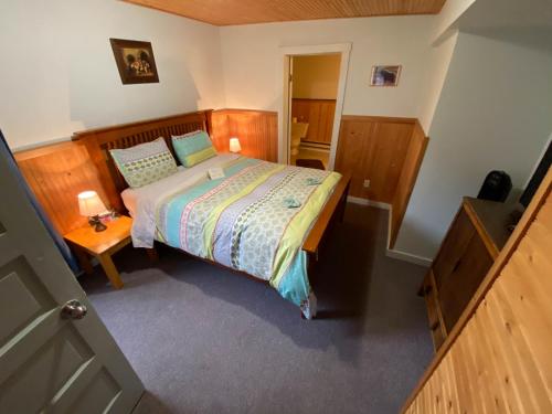 a small bedroom with a bed and a table at Historic Hotel Bayview in Stewart