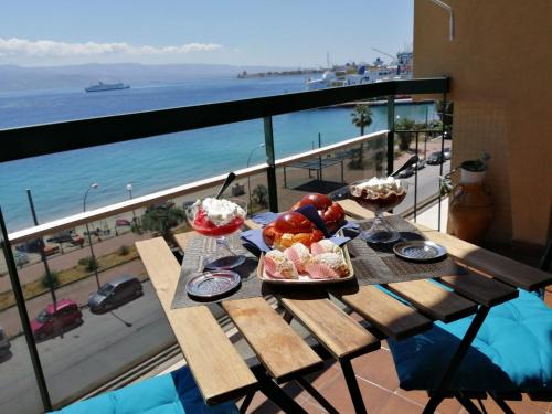a table with food on it with a view of the ocean at The door of Sicily in Messina