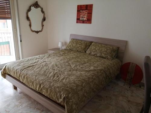 - une chambre avec un lit et un miroir mural dans l'établissement The door of Sicily, à Messina