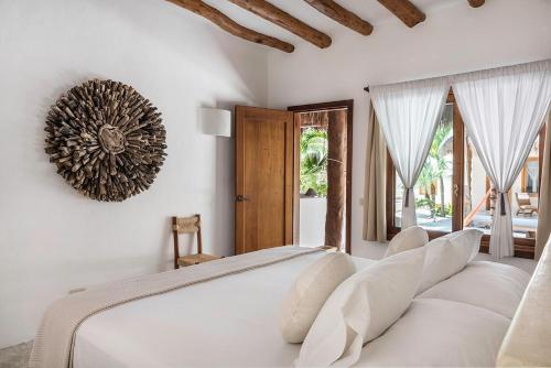 a bedroom with a large white bed with white pillows at Tierra del Mar Hotel - Adults Only in Holbox Island