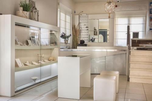 a kitchen with glass shelves and a white counter at Captain's House Hotel in Skala Kefalonias