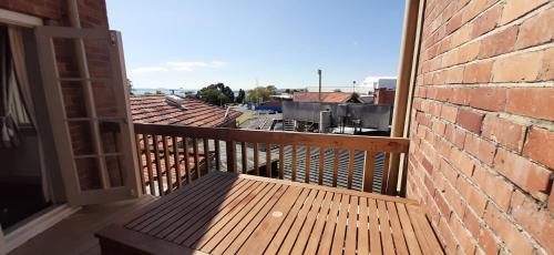 a balcony with a wooden bench on a brick building at The Prospect of Howick Accommodation in Auckland