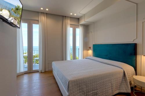 una camera con un grande letto e vista sull'oceano di Diecidodici BoutiqueRooms a Sirolo