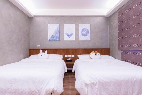 2 camas con almohadas de Hello Kitty en un dormitorio en 幾何拼圖民宿 en Magong