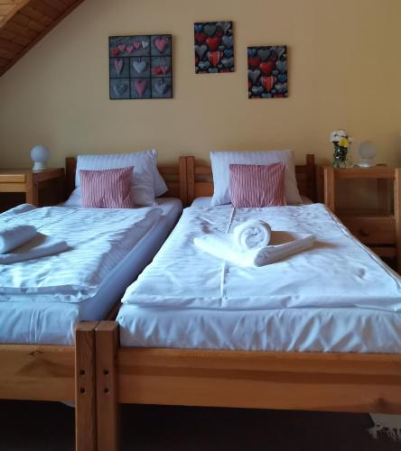 two beds in a bedroom with towels on them at hotel ZLATÝ POTOK in Nicov