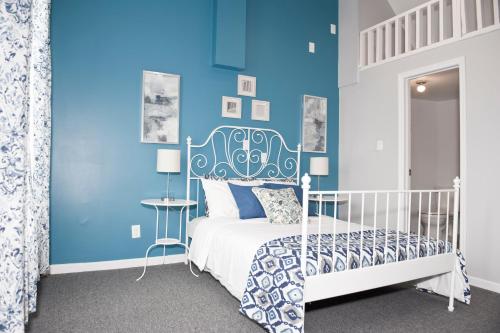 a blue bedroom with a white bed and a blue wall at Dream Catcher Travel House in Toronto